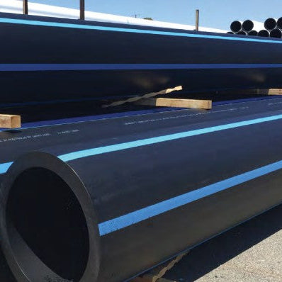 Large black pipes with blue stripes on a concrete surface